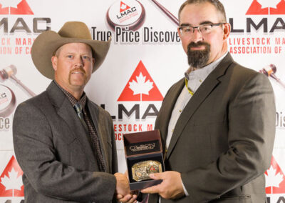 2nd Runner up, Kirk Goldsmith sponsored by the VJV Marketing Group from Ponoka, Alberta, picks up the Canadian Simmental Association Buckle presented by SCA representative, Dwayne Martin.