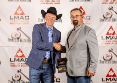First Runner-Up winner Tyler Rosehill receives the Canadian Simmental Association buckle from Dwyane Marten of the Canadian Simmental Association.