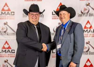 LMAC President Allan Munroe congratulates LMAC Champion Auctioneer Dave Jacob on winning the $ 1,200 cash prize from LMAC to offset expenses while competing in the International Livestock Auctioneering competition at the Calgary Stampede.